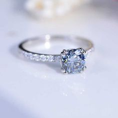 a white diamond ring sitting on top of a table