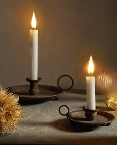 three lit candles sitting on top of a table