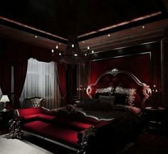 a large bed sitting in the middle of a bedroom next to a red couch and table