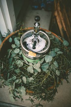 a potted plant sitting on top of a wooden barrel filled with water and leaves