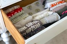 an open drawer filled with socks on top of a bed