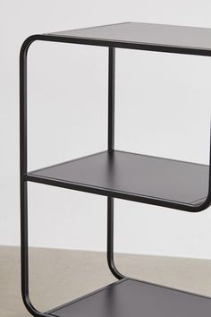 a black metal shelf with two shelves on each side and one shelf below the shelf