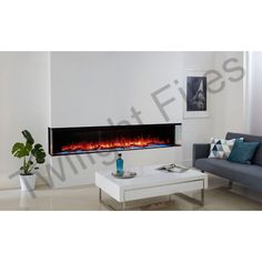 an electric fireplace in the living room with white walls and blue pillows on the floor