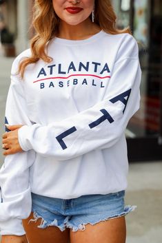 Calling all Braves fans, the White Atlanta Baseball Sweatshirt was made just for you! This comfy sweatshirt is designed with a soft and stretchy knit with a fleece interior. It features a crew neckline, long sleeves with "ATL" down them, a relaxed fit, and the words "Atlanta Baseball" on the front. Style the White Atlanta Baseball Sweatshirt with your favorite denim and a baseball hat for a cute game day look! Jerzees Brand Soft + Stretchy Knit Fabrication Fleece Interior "Atlanta Baseball" Grap Cute Game, Baseball Sweatshirts, Cute Games, Comfy Sweatshirt, Baseball Hat, Large Bust, White Sweatshirt, Small Bust, Game Day