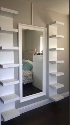 there is a mirror in the room with shelving on the wall next to it