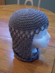 a knitted hat sitting on top of a wooden table