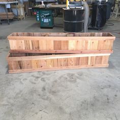 two wooden planters sitting on top of a cement floor