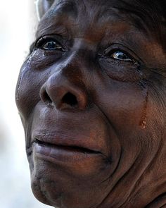 an old woman with wrinkles and tears on her face looking off to the side