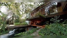 a car is parked in front of a house with trees and plants on the side