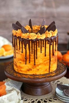 an orange cake with chocolate drizzles on top, sitting on a table