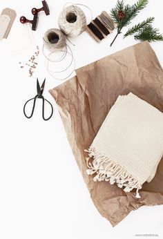 craft supplies laid out on top of a piece of brown paper with scissors and twine