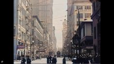 an old photo of people walking down the street in new york city, with tall buildings on either side