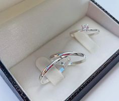 two silver rings sitting in a box on top of a table