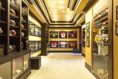 the inside of a football locker with many framed pictures on the wall and shelves full of memorabilia