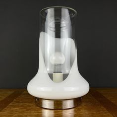 a glass vase sitting on top of a wooden table