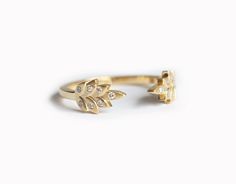 a gold ring with two small leaves on the front and one smaller leaf on the back