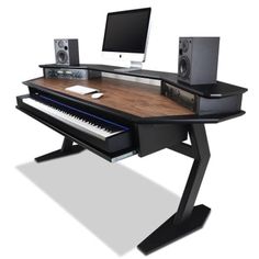 a computer desk with a keyboard, monitor and speakers sitting on it's sides