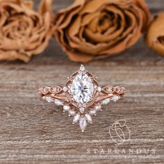 a close up of a ring on a wooden surface with roses in the back ground