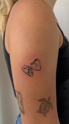 a woman with a tattoo on her arm has a turtle and an envelope in the shape of a heart