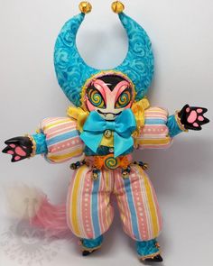 a toy doll is dressed in colorful clothing