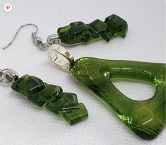 green glass earrings with silver hooks on white background