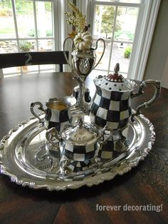 a silver tea set sitting on top of a wooden table