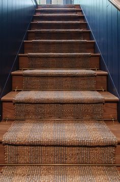 a set of stairs leading up to a building with blue walls and carpeted steps