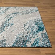 a blue and white rug on top of a wooden floor