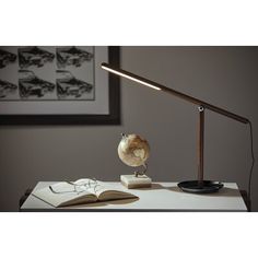 a desk lamp sitting on top of a table next to an open book