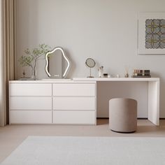 a white dresser with a mirror and stool in a room next to a large window