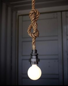 a light bulb with a rope hanging from it's end, in front of a garage door