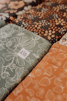 an orange and green patchwork quilt with white flowers on it's sides, along with the label that says happy