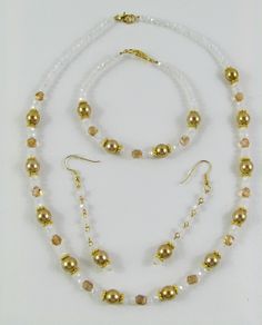 This set is made with gold glass pearls, white opaque faceted glass beads, gold faceted glass beads and gold accents. The necklace is 18 inches The bracelet is 7 1/2 inches The earrings are 2 inches White Pearl Jewelry With Faceted Beads, Elegant Gold Beaded Bracelets With Czech Glass, Gold Pearl Beaded Necklaces With Spacer Beads, Adjustable Gold Beads For Costume Jewelry, Gold Czech Glass Round Beads Jewelry, Gold Costume Jewelry With Faceted Beads, Gold Pearl Jewelry With Faceted Beads, Gold Pearl Necklace With Faceted Beads, Gold Pearl Necklace With Faceted Beads For Party