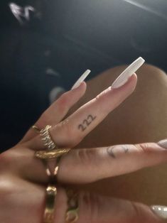 a person with two fingers and tattoos on their hands, one has the letter n in it's middle finger