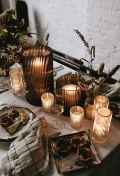 the table is set with candles and plates