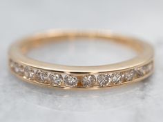 The simple lines and bright, polished gold compliment nicely with the row of diamonds channel set down the center! This can be worn as a dinner ring, right hand ring, cocktail ring, anniversary band, promise ring, alternative engagement ring... The low profile and simple shape mean it can be worn just about anywhere, anyway, with or without other rings stacked next to it!Metal: 14K Yellow Gold Gem: 12 Diamonds totaling .24 Carat, H-J in Color, SI-I in Clarity Width of Band: 2.6 mmHeight off Finger: 2.4 mmRing Size: 5Marks: "A51 14K" Stamped on the inside band Plain Gold Wedding Bands, Channel Set Diamond Engagement Ring, Rings Stacked, Dinner Ring, Wedding Band Diamond, Enhancer Wedding Band, Plain Wedding Band, Right Hand Ring, Alternative Engagement Ring