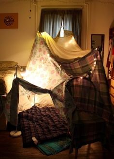 a tent is set up in the middle of a room with other items on the floor