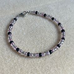 - One Of A Kind Beaded Charm Bracelet - Featuring Clear Translucent, Purple Translucent, And Black Seed Beads - Silver Colored Hardware - Clasps Closed. No Stretch. - Size/ Circumference Is 7.5” - Handmade (By Myself). Perfect To Treat Yourself Or To Give As A Gift! **Add 2 Jewelry Items Marked “2 For $20” To Your Bundle And I Will Send You An Offer For $20** Check Out The “Boutique” Tab In My Closet For Handmade Earrings, Bracelets, And Necklaces! Adjustable Purple Bracelet With Black Beads, Adjustable Purple Bracelets With Black Beads, Purple Beaded Bracelets With Black Beads As A Gift, Small Bead Bracelet, Purple Beaded Bracelets, Beaded Charm Bracelet, Yellow Bracelet, Blue Beaded Bracelets, Black Beaded Bracelets