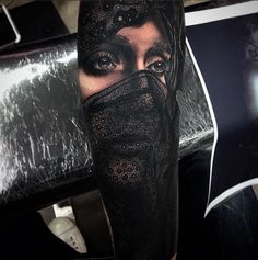 a woman's face covered in black lace on her leg with an eye patch