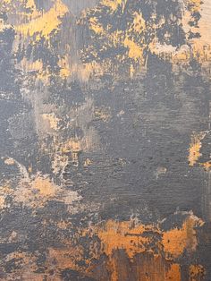 an orange and black background with some yellow paint on it's surface, as well as other colors