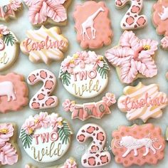 decorated cookies with pink and white icing are displayed on a sheet of paper that says two wild