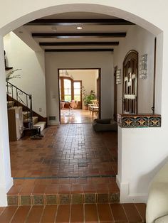 an archway leading to a living room and dining area with tile flooring on both sides