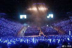 a large group of people in an arena with blue lights