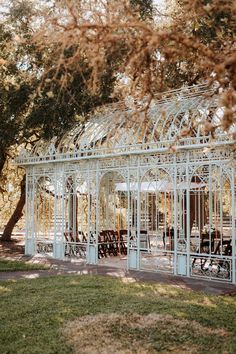 a white metal structure sitting in the middle of a park