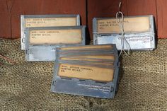 three old video game consoles sitting on top of a burlap covered table next to a wooden door