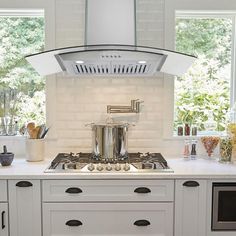 a stove top oven sitting inside of a kitchen next to a window with lots of windows