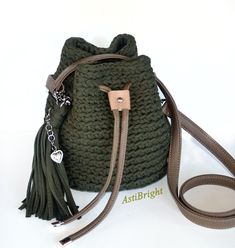 a crocheted bag with a tasseled strap and a keychain