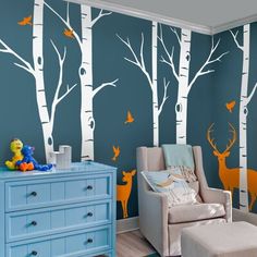 a baby's room with blue walls and white birch trees