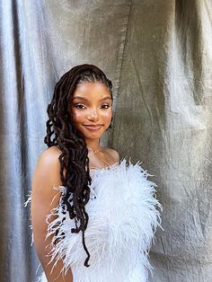 a woman in a white feathered dress posing for a photo with her hands on her hips