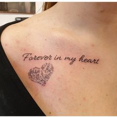 a woman with a tattoo on her chest saying, forever in my heart